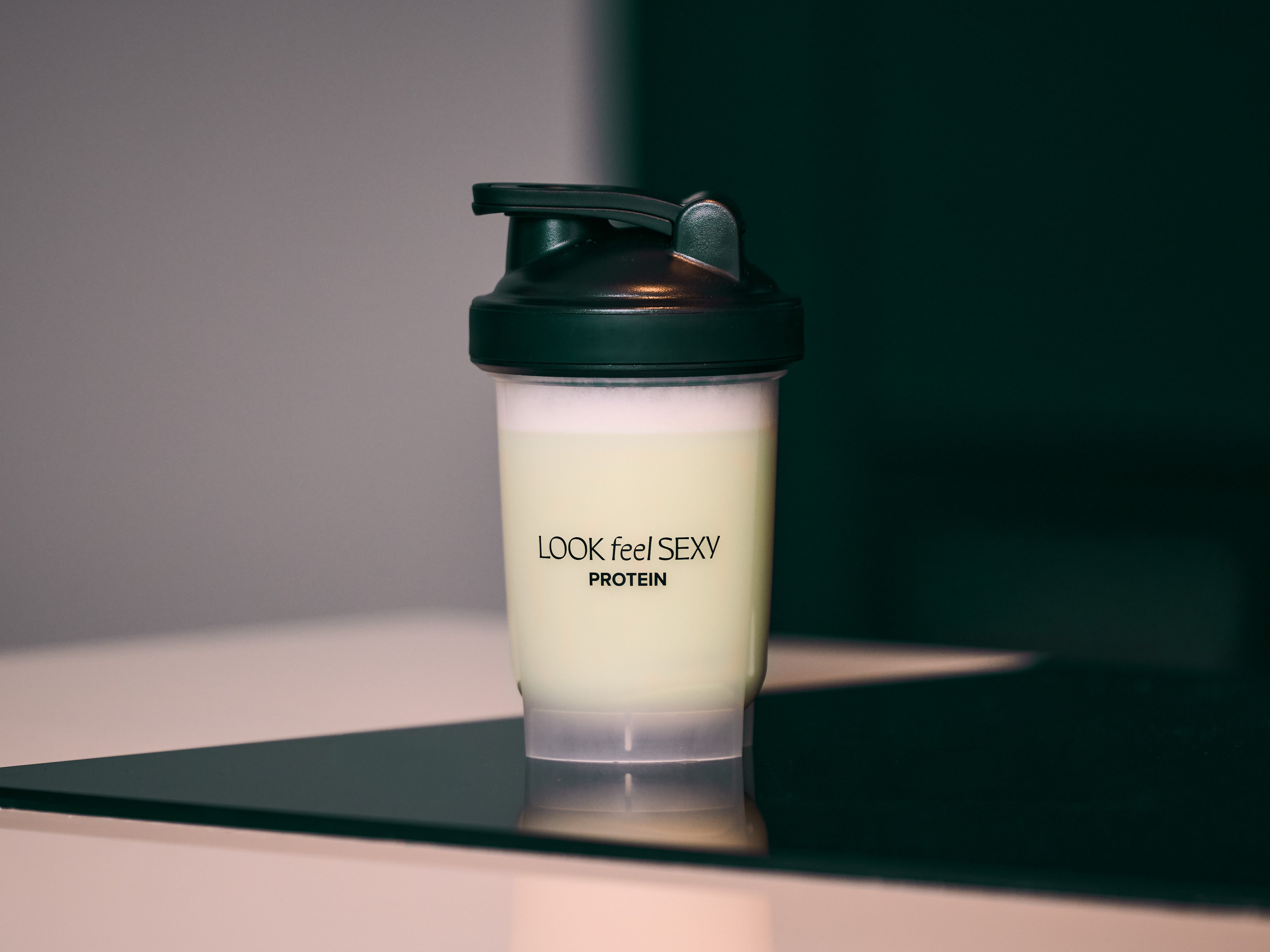 Protein shaker with 'LOOK feel SEXY' branding on a reflective surface.